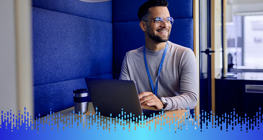 Homem sorridente usando óculos e trabalhando com laptop em ambiente digital workplace, promovendo produtividade e inovação.