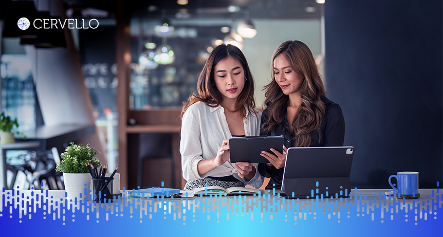 Duas mulheres trabalhando com tecnologia em um ambiente de escritório, promovendo automação empresarial eficiente.